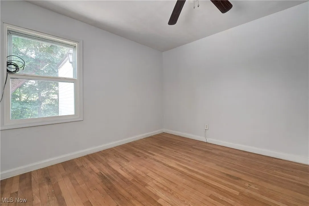 Empty room with light wood finished floors and a ceiling fan