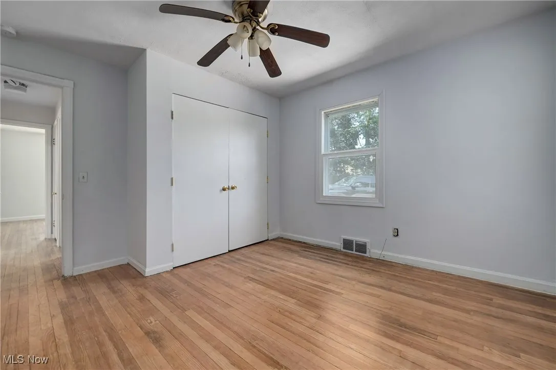 Unfurnished bedroom featuring light wood-type flooring, a closet, and a ceiling fan