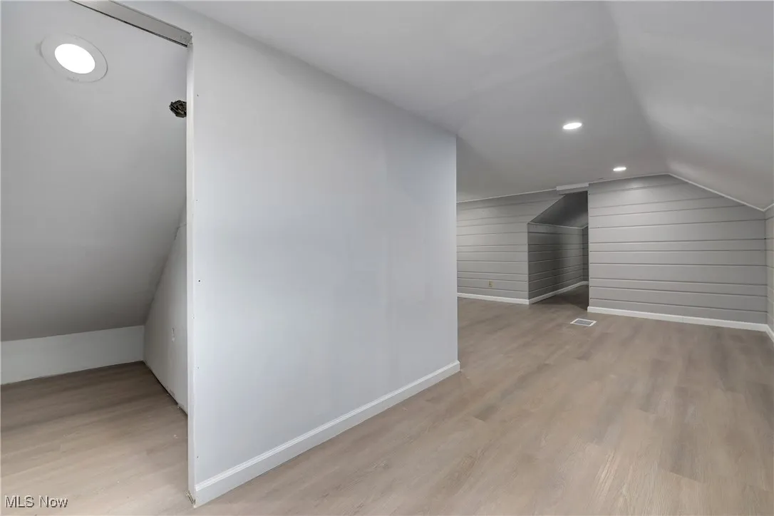 Bonus room with vaulted ceiling, light wood-style flooring, and recessed lighting