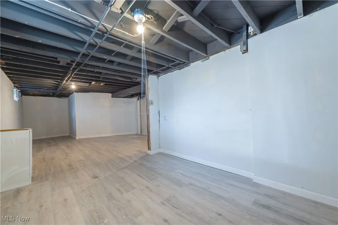 Finished basement featuring wood finished floors and baseboards