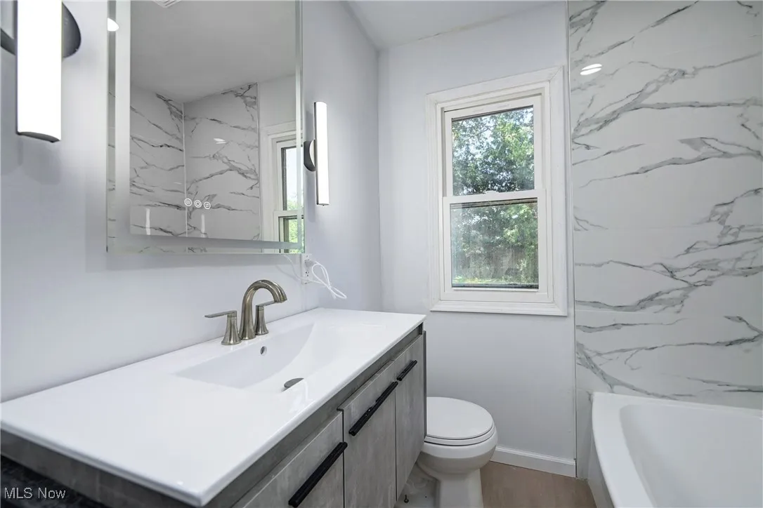 Bathroom with vanity, a tub to relax in, and a shower