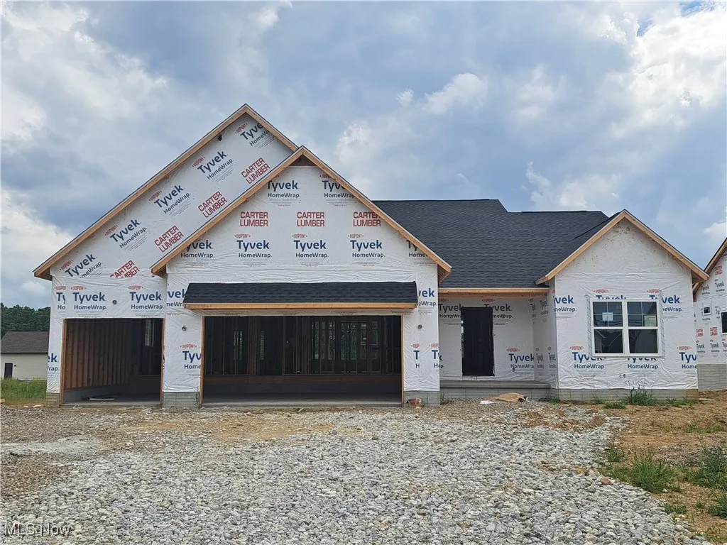 Property under construction with a garage and a shingled roof