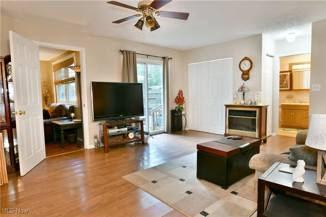 Living room with ceiling fan and light wood finished floors