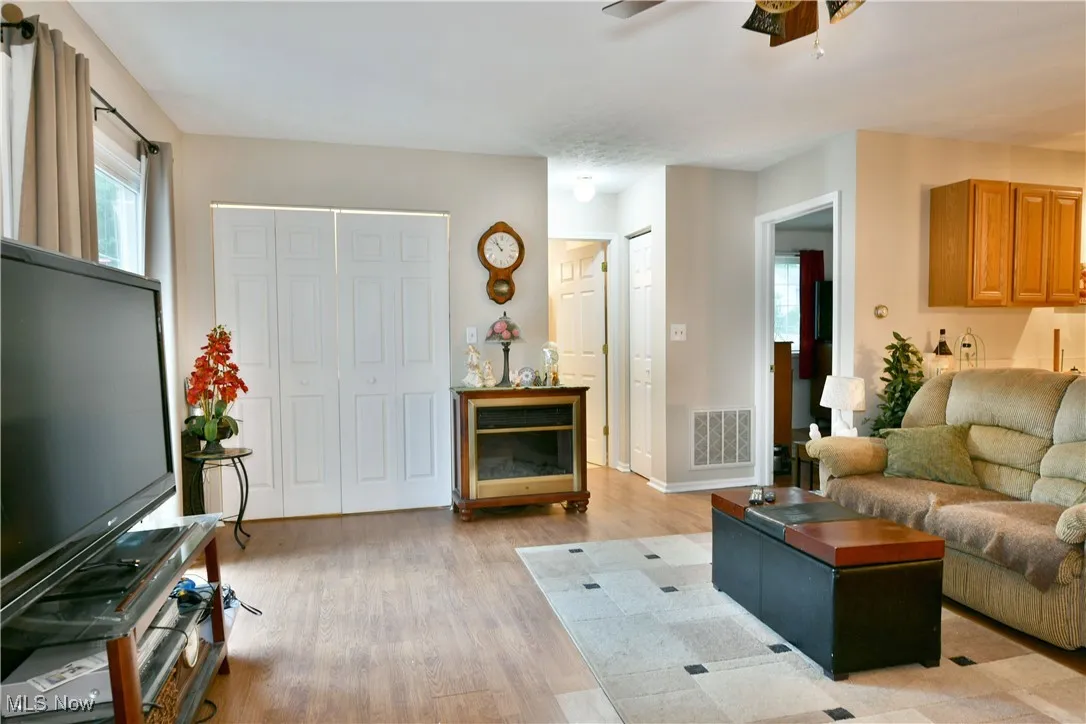 Living area featuring light wood-style flooring and ceiling fan