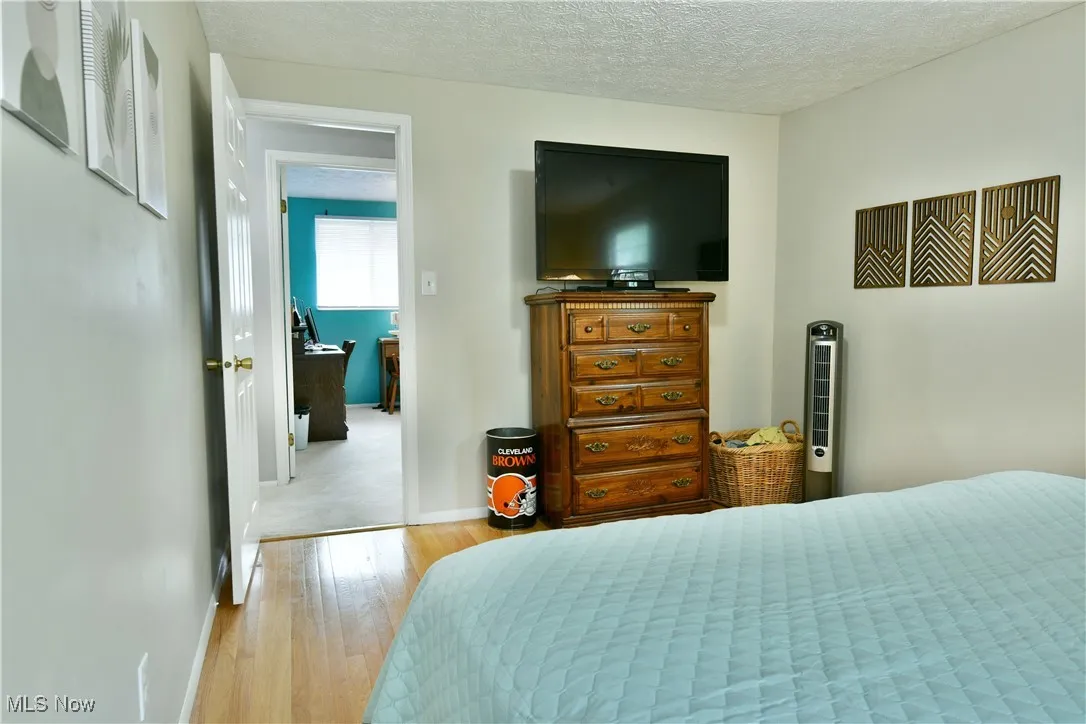Bedroom featuring hardwood / wood-style flooring and a textured ceiling