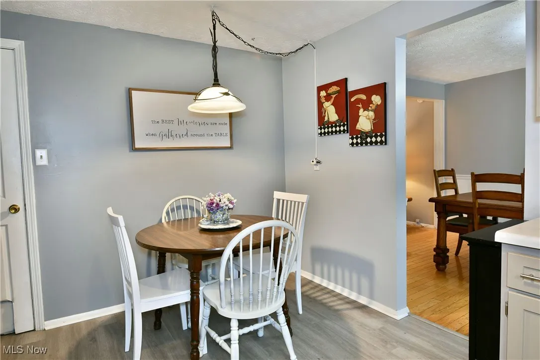 Dining space with light wood finished floors and a textured ceiling