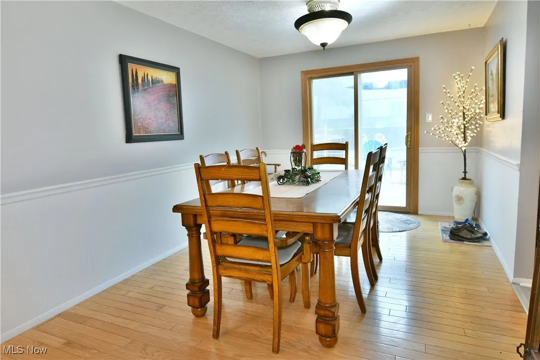 Dining space featuring light wood-style floors and a wainscoted wall