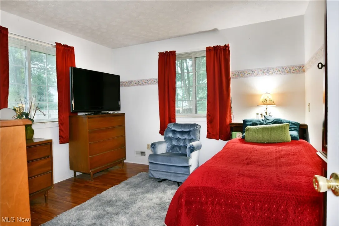 Bedroom with wood finished floors and a textured ceiling