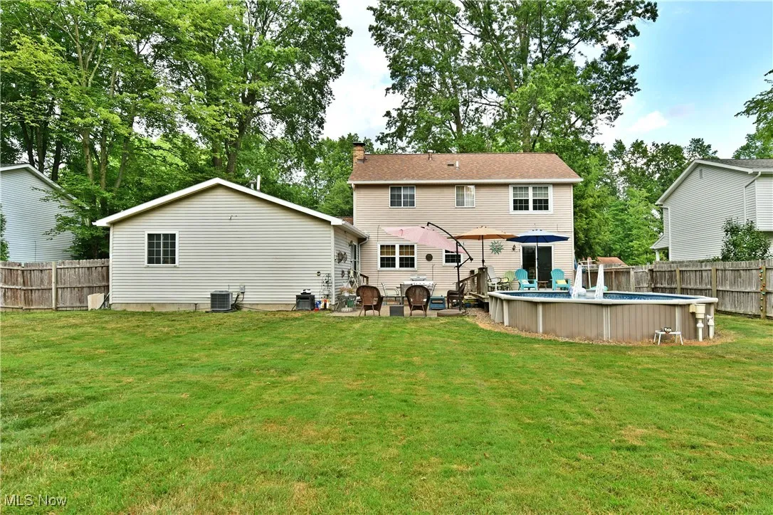 Rear view of house featuring a fenced backyard and a chimney