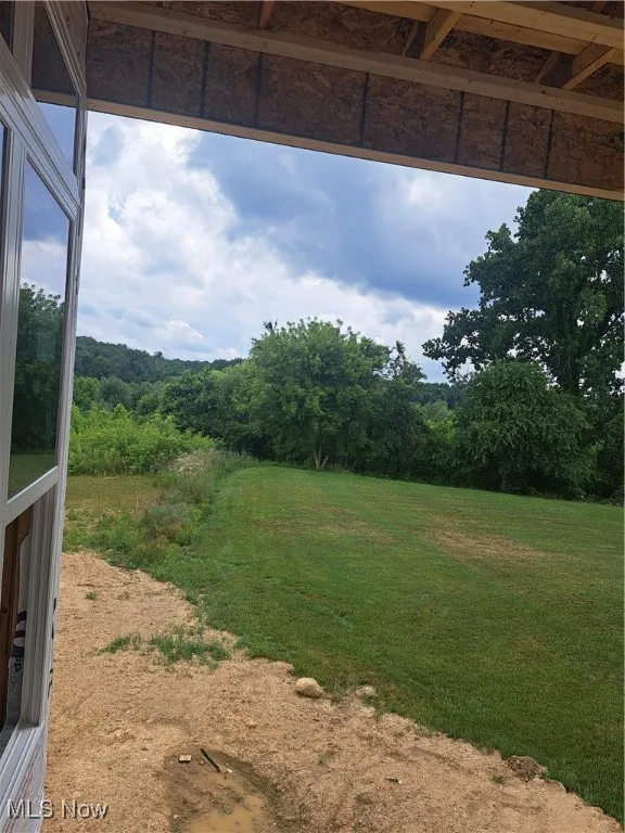 View of green lawn featuring a forest view