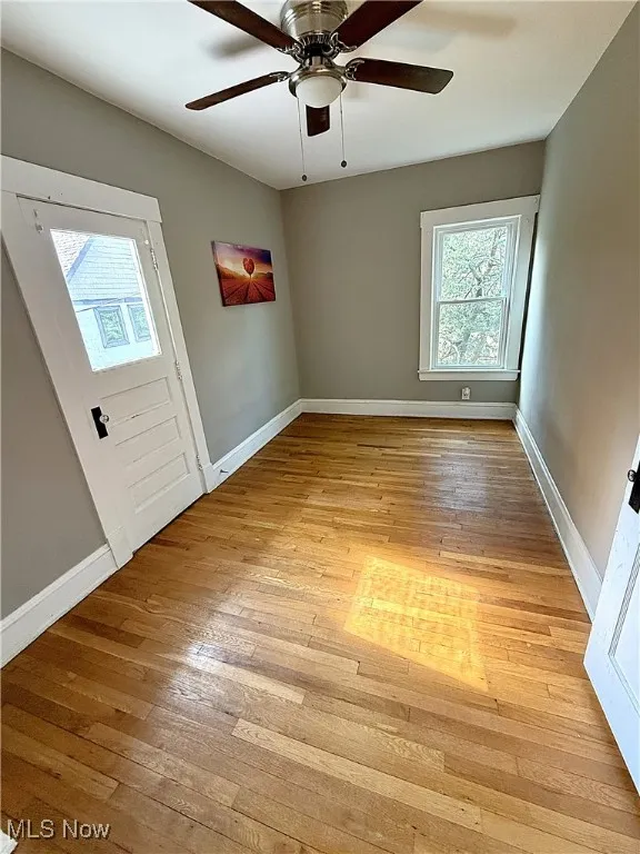 Master bedroom with light wood-type flooring, lots of natural light, and ceiling fan