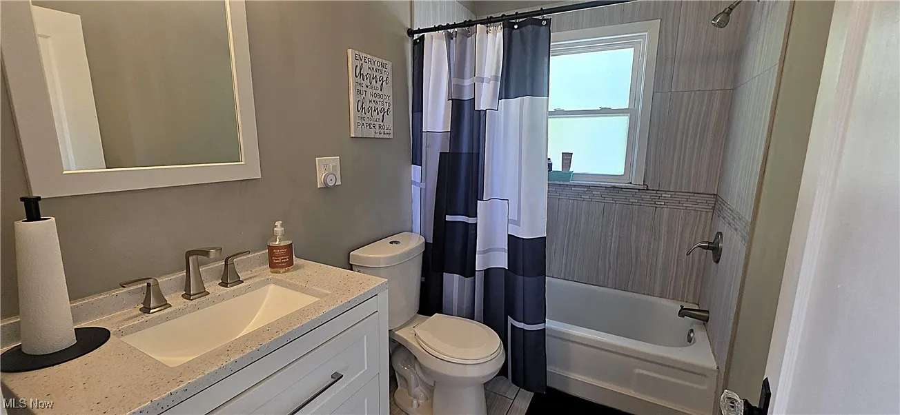 Full bathroom featuring vanity and shower / bathtub combination with curtain