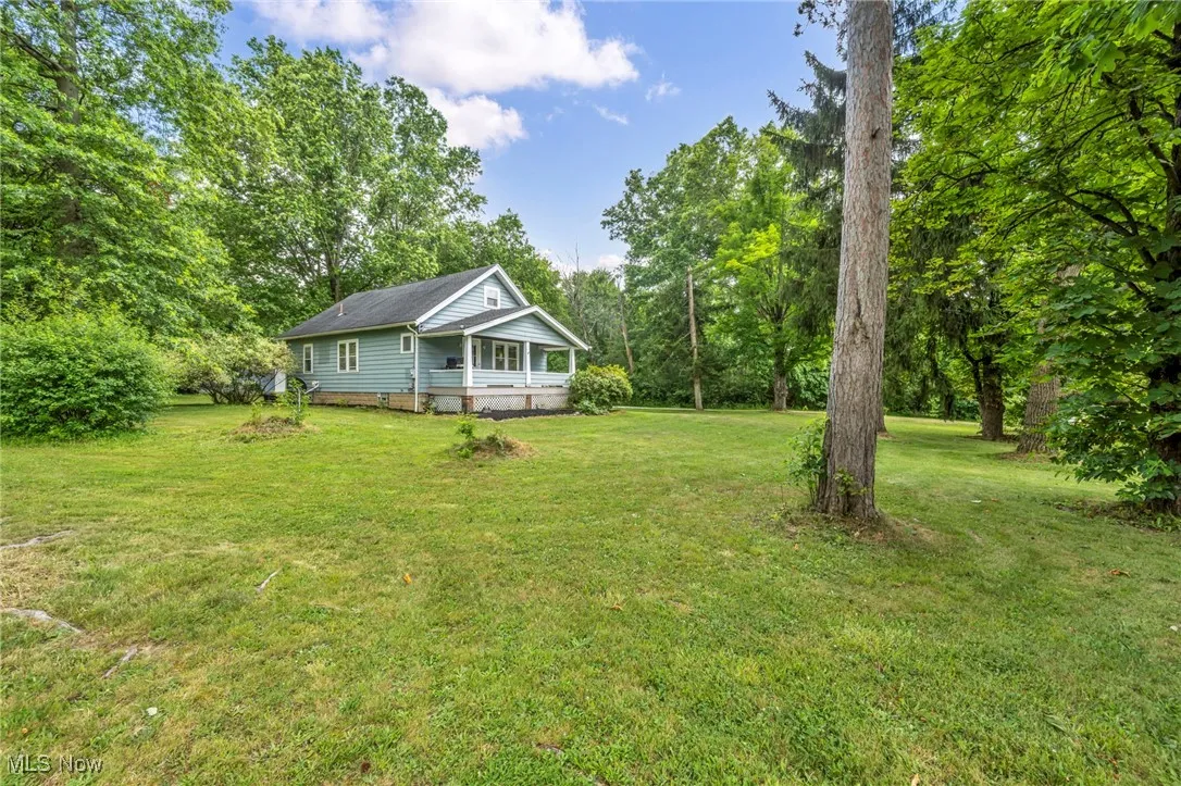View of green lawn featuring a porch