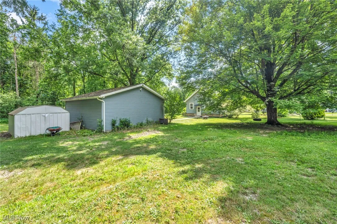 View of grassy yard featuring a storage shed