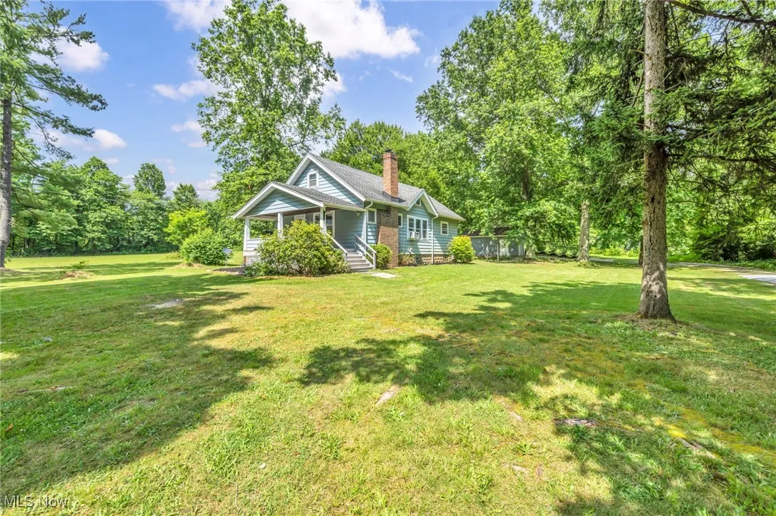 View of green lawn featuring covered porch