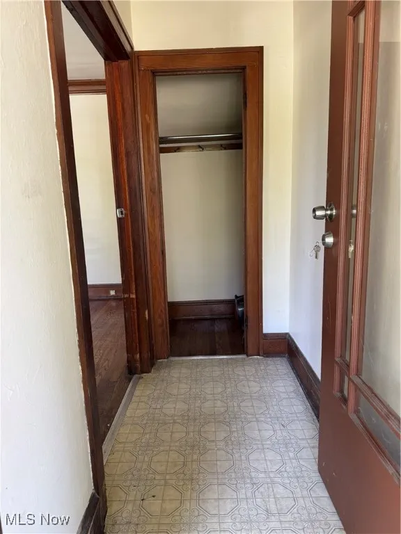 Hallway with tile patterned floors and baseboards
