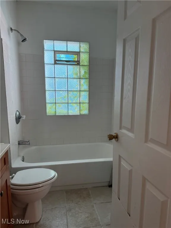 Bathroom with vanity, tub / shower combination, and tile patterned floors