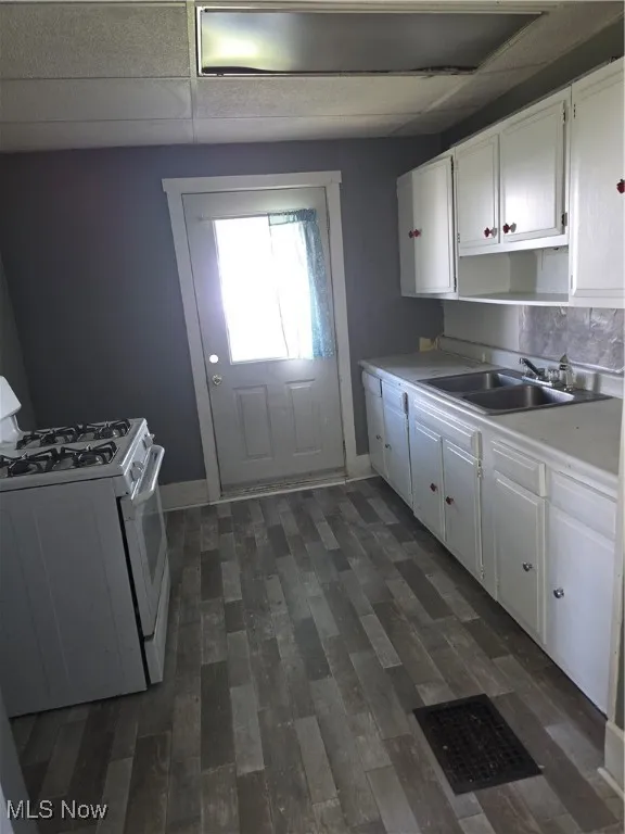 Kitchen featuring range, white cabinetry, and light countertops