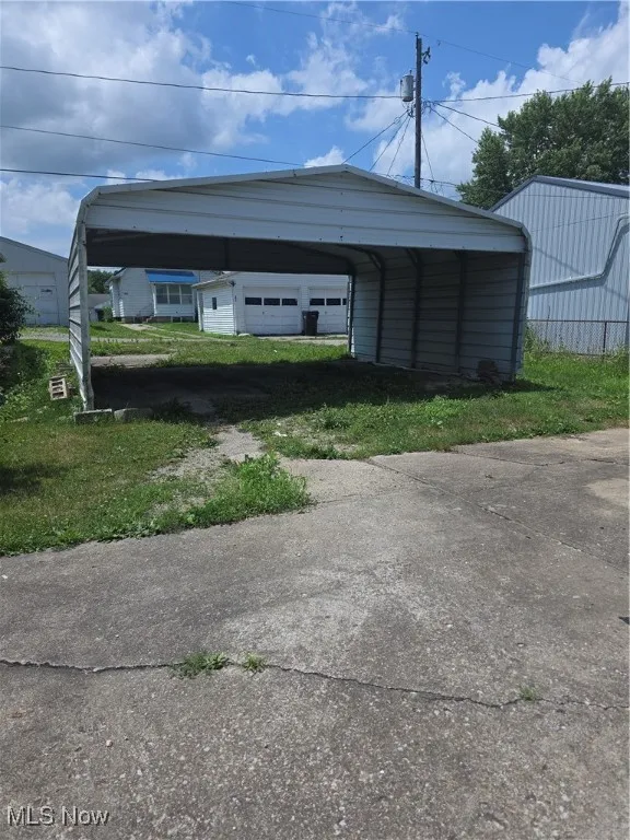 View of parking / parking lot featuring driveway and a detached carport