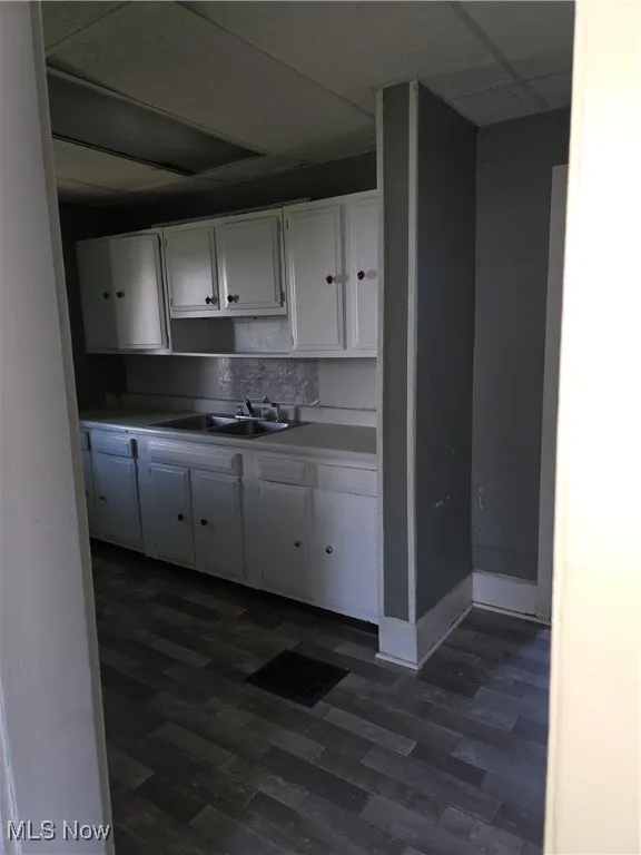 Kitchen featuring white cabinetry and dark wood-type flooring