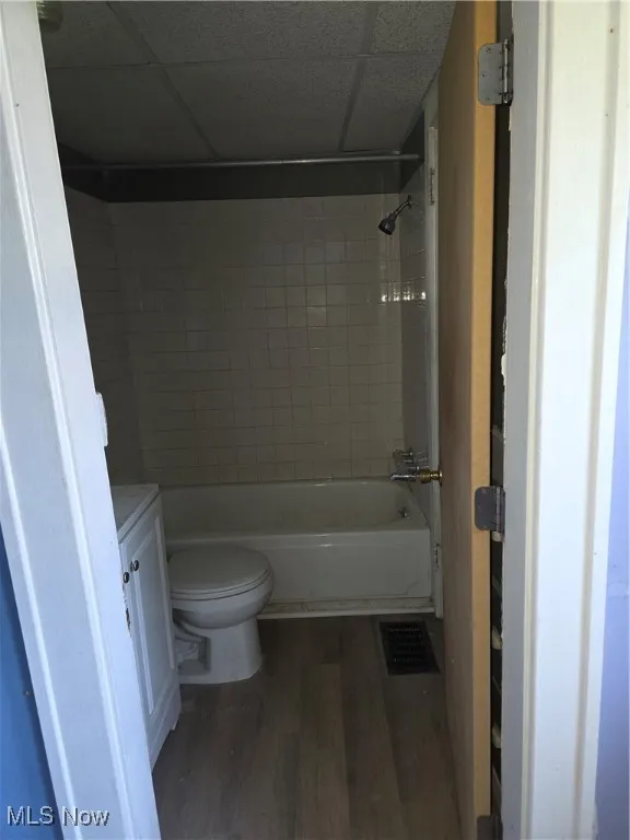 Full bathroom with wood finished floors, vanity, a paneled ceiling, and shower / bathtub combination