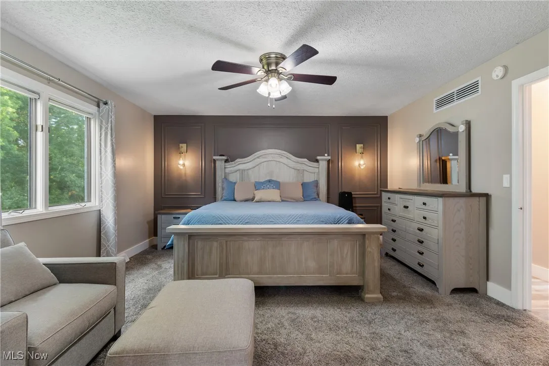 Carpeted bedroom featuring baseboards and ceiling fan
