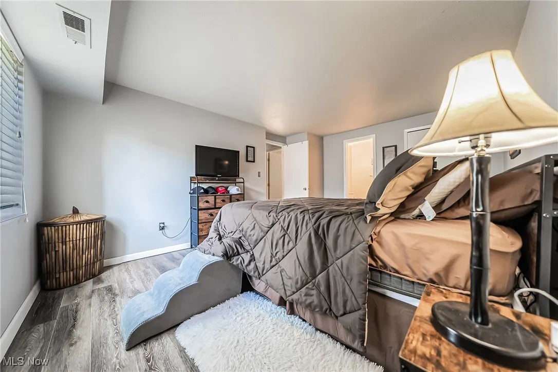 Bedroom with wood finished floors and baseboards