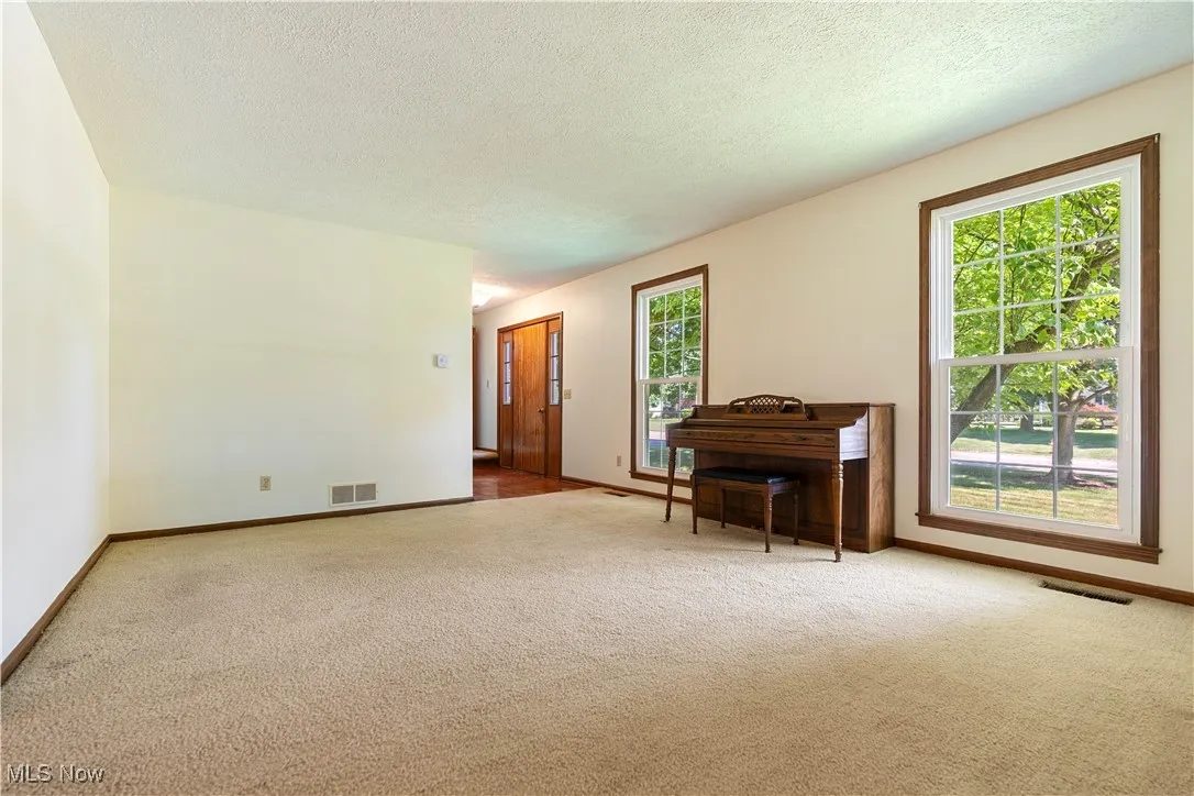 View of living room and foyer.  Look at these windows providing so much natural light.