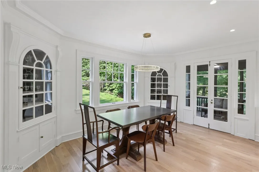 Dining room with ornamental molding, light wood-style flooring, and recessed lighting