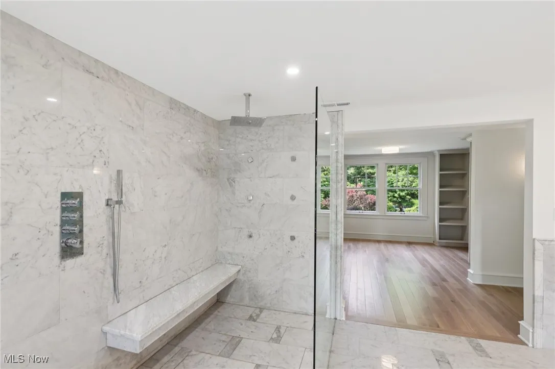 Full bathroom featuring a marble finish shower, wood finished floors, and recessed lighting
