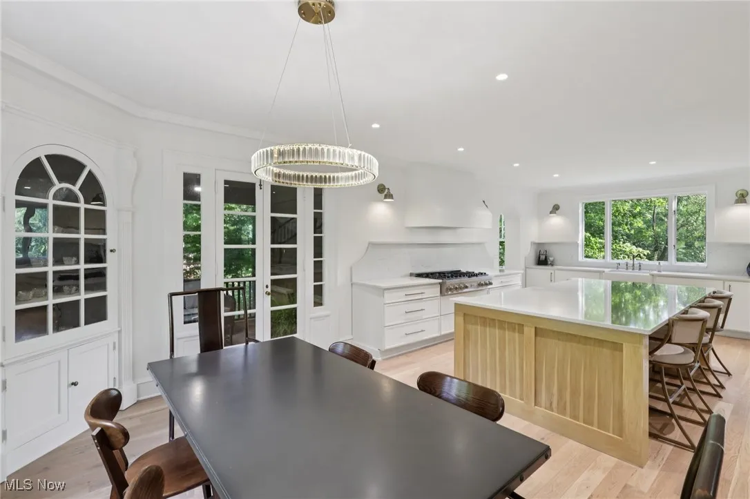 Dining area with light wood-type flooring, recessed lighting, crown molding, and a chandelier