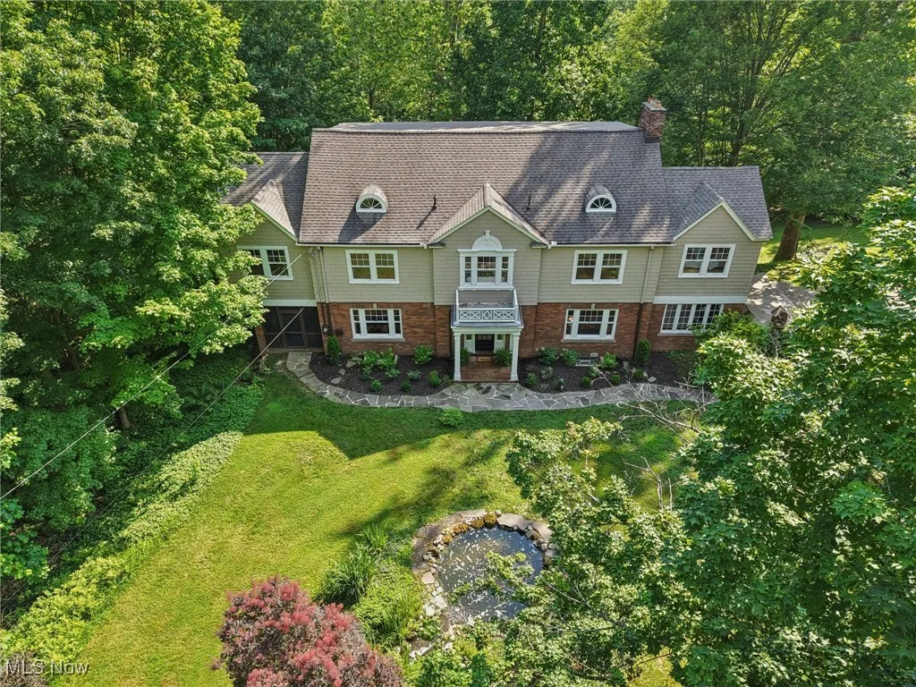 Shingle-style home with a front lawn and a chimney