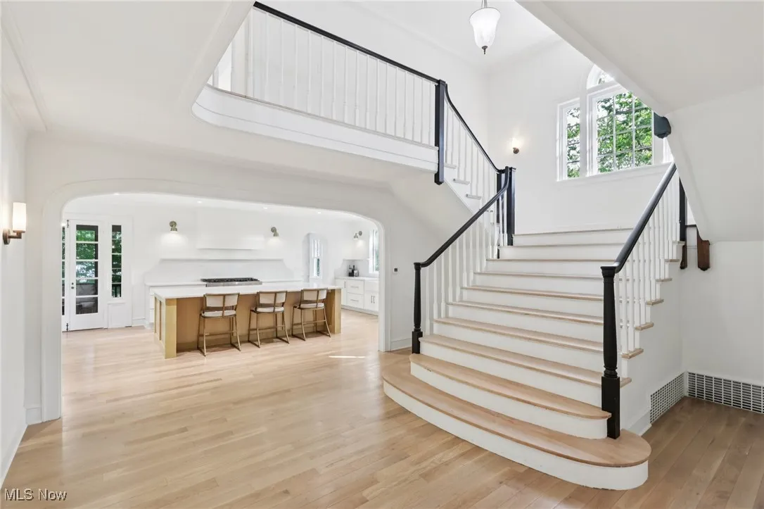 Stairway with arched walkways and wood finished floors