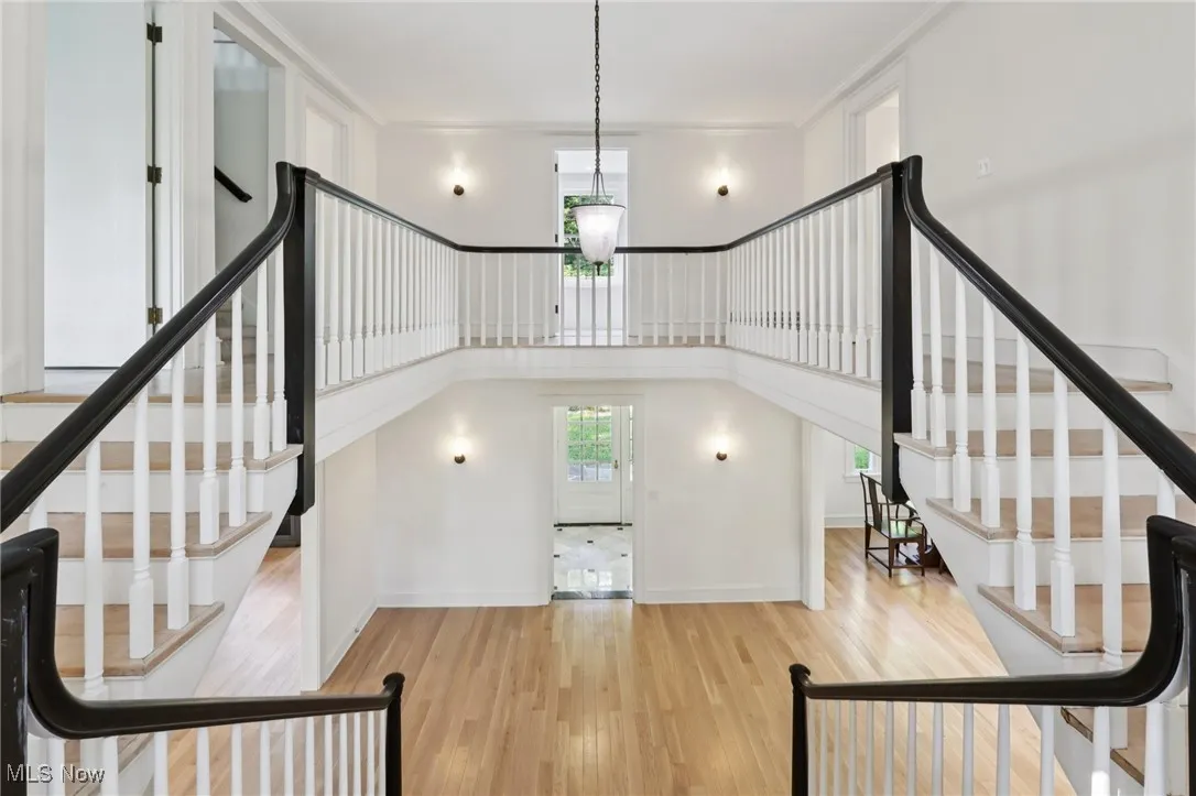 Stairway with wood finished floors and baseboards