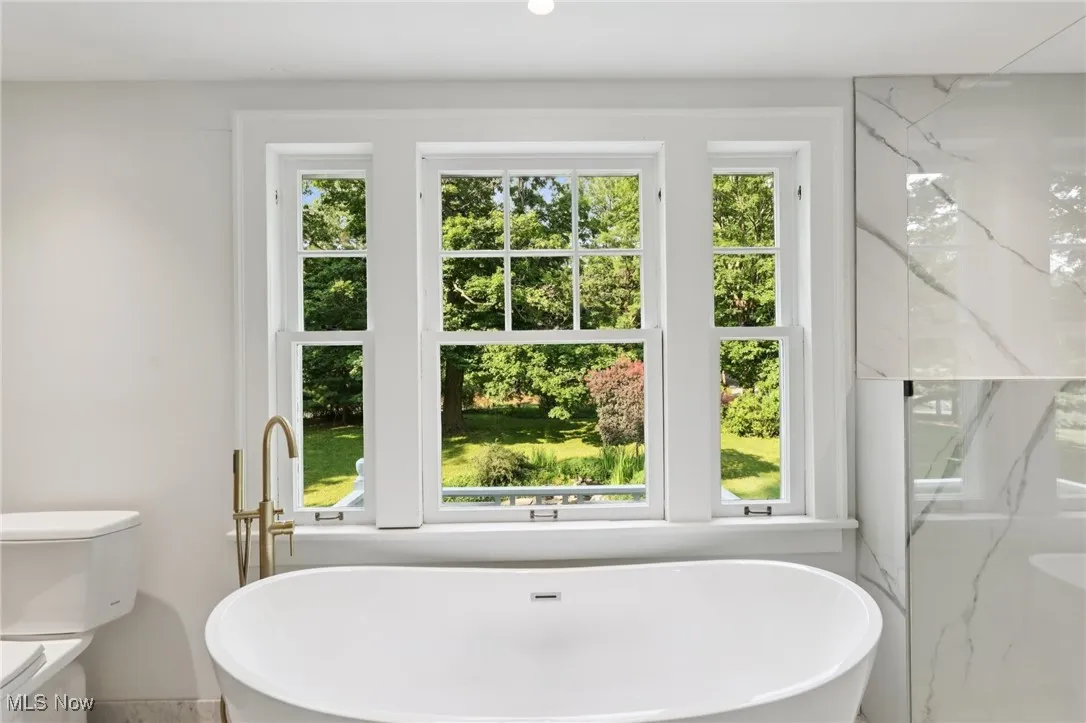 Full bath with plenty of natural light and a soaking tub