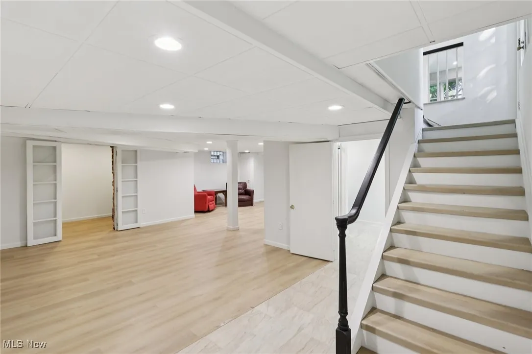 Finished below grade area featuring stairway, recessed lighting, and light wood finished floors