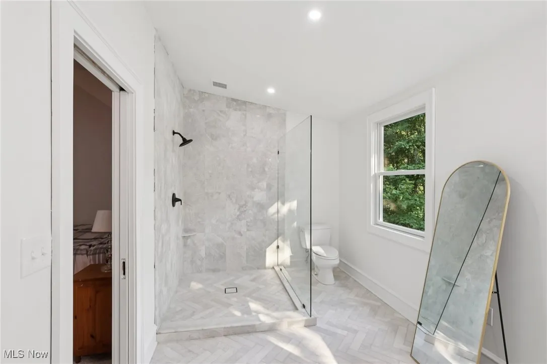 Bathroom featuring tiled shower and recessed lighting