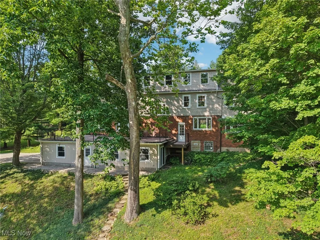 Rear view of property with brick siding and a yard