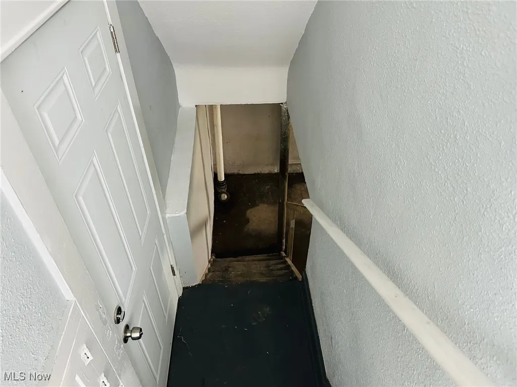 Stairway featuring a textured wall
