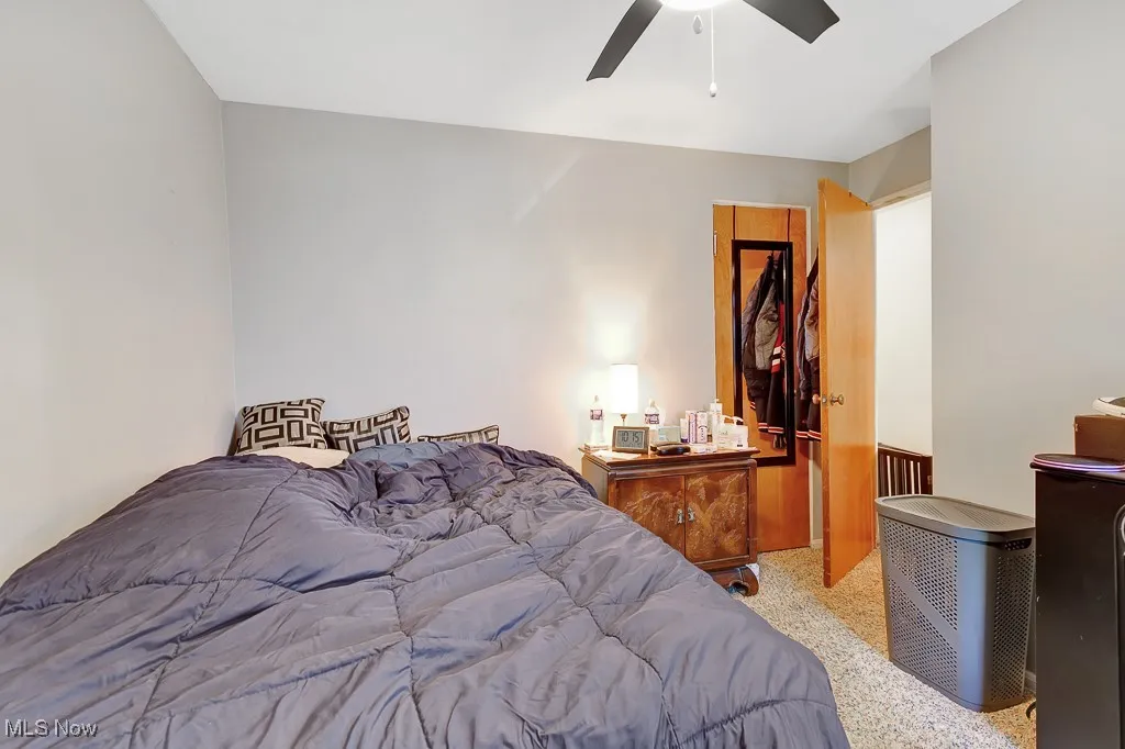 Bedroom with speckled floor and ceiling fan
