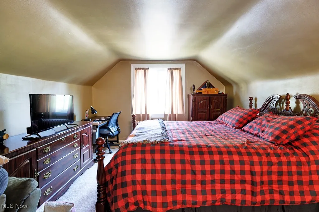 Bedroom with carpet flooring and vaulted ceiling