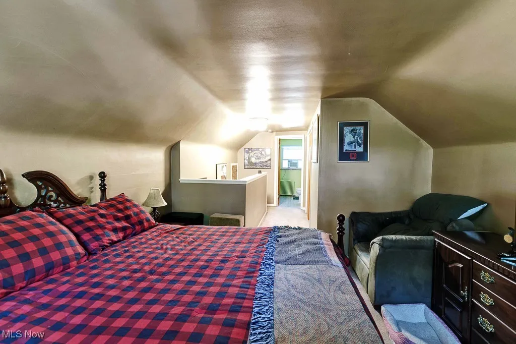 Carpeted bedroom featuring vaulted ceiling