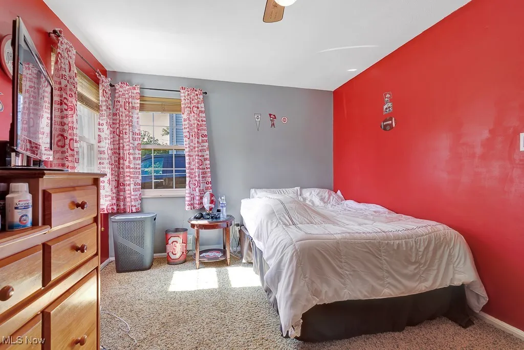 Carpeted bedroom featuring baseboards and ceiling fan
