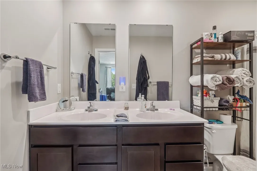 Ensuite bathroom featuring double vanity and toilet