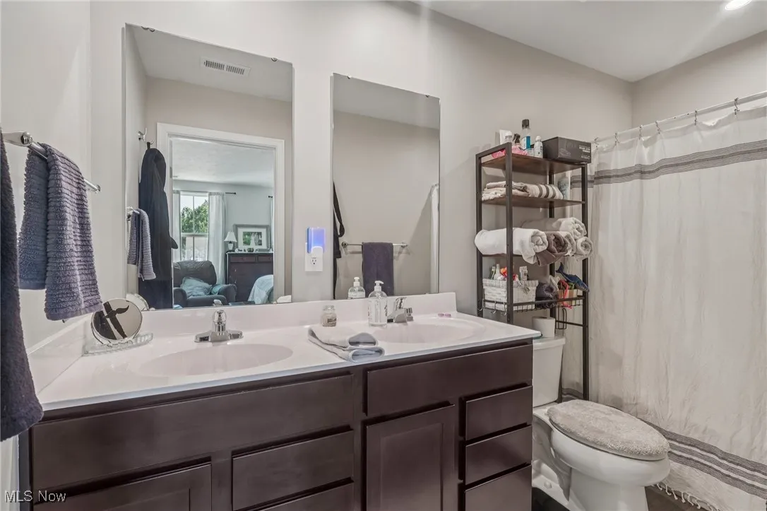 Full bath featuring ensuite bath, double vanity, and curtained shower