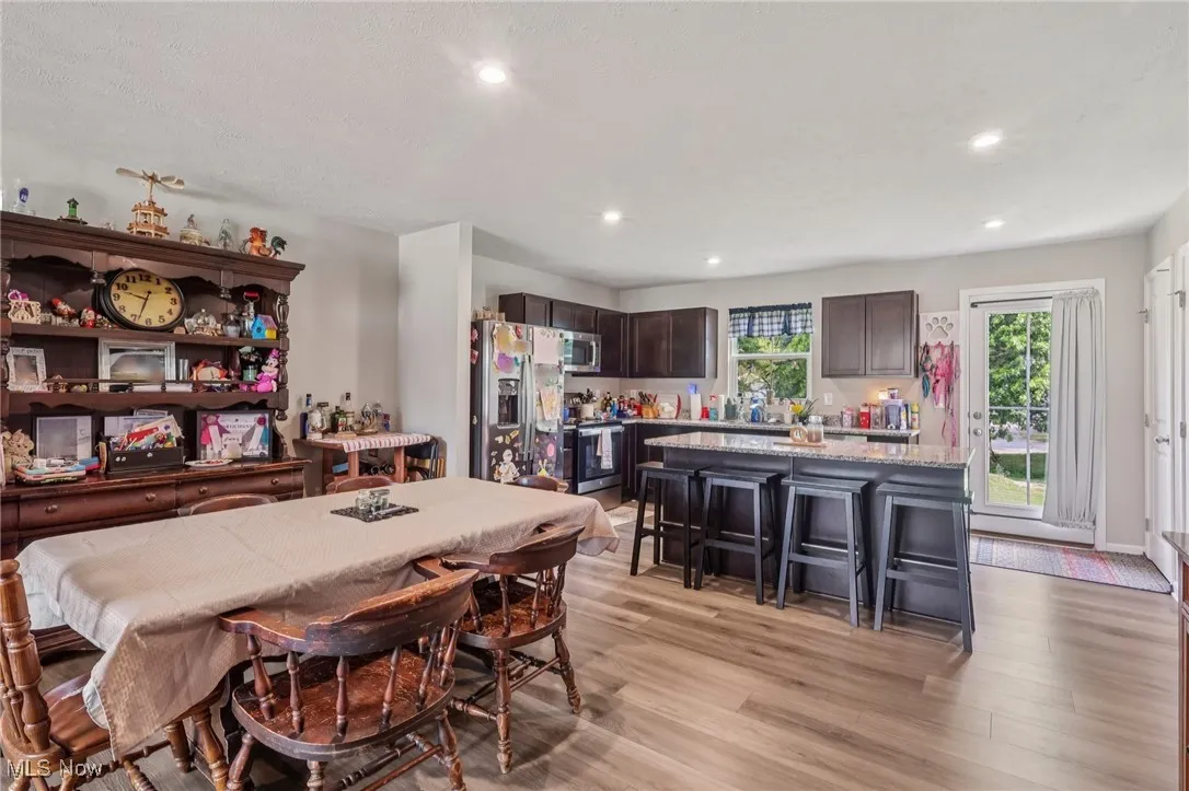 Dining area with light wood finished floors and recessed lighting