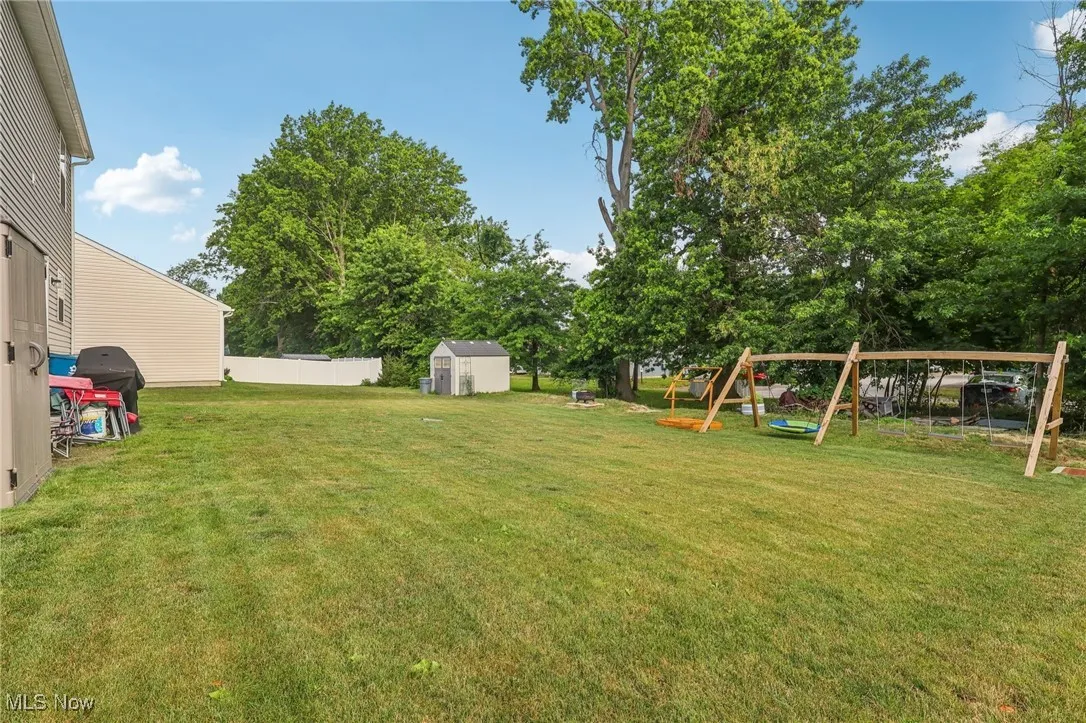 View of yard with a playground and a shed