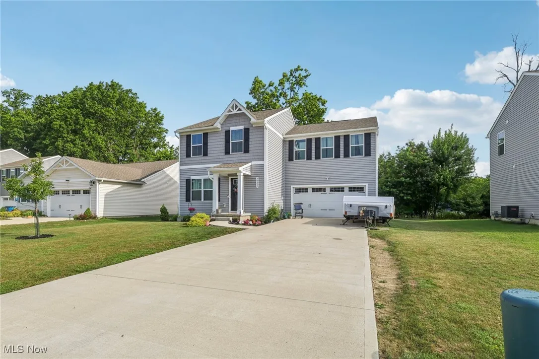 View of front of house with driveway, a front lawn, and an attached garage