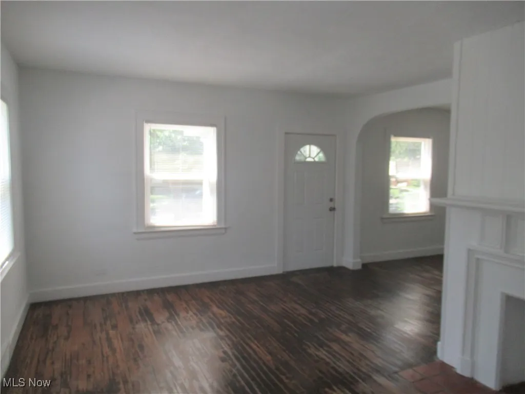 Entryway featuring plenty of natural light, arched walkways, and wood finished floors