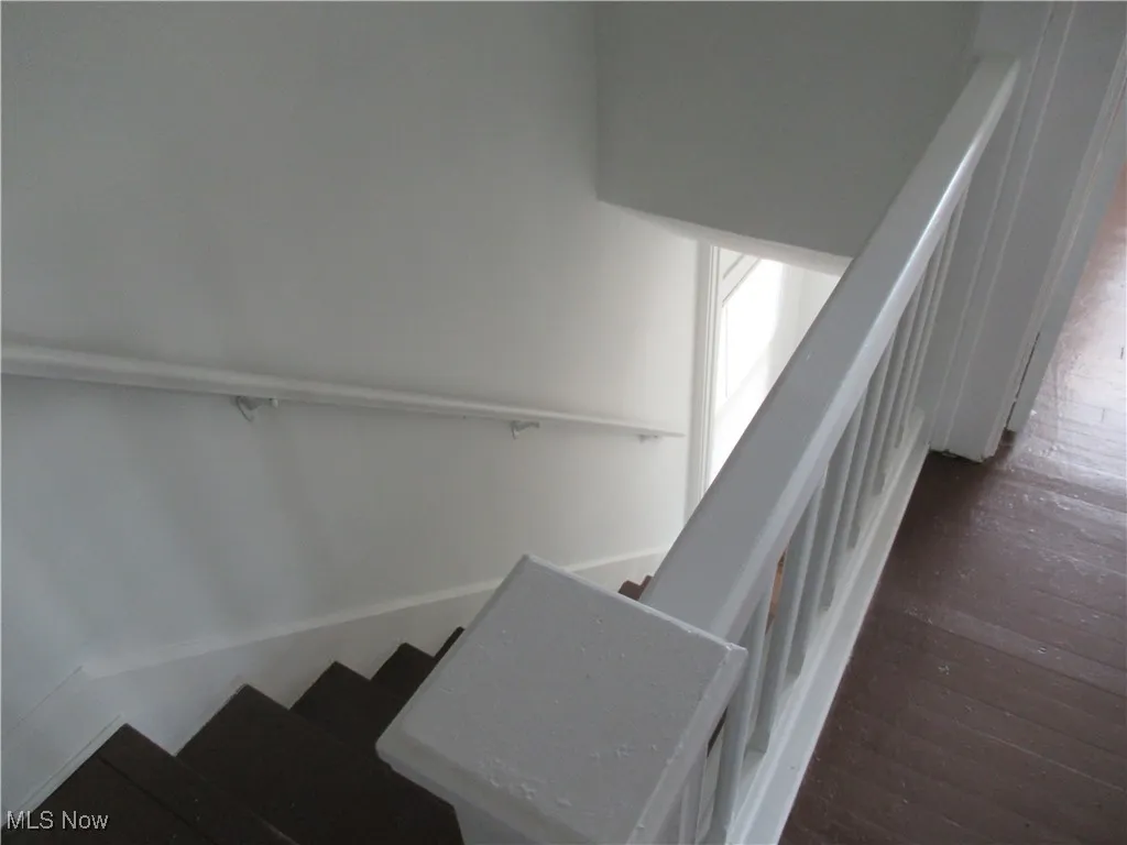 Staircase featuring hardwood / wood-style flooring